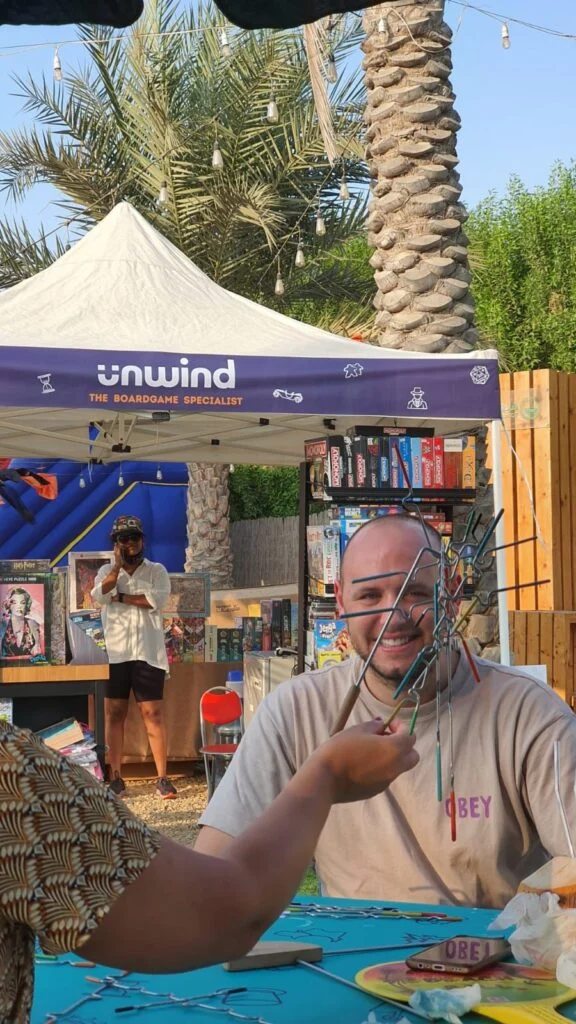An Unwind Game Master playing with guests at an event stall