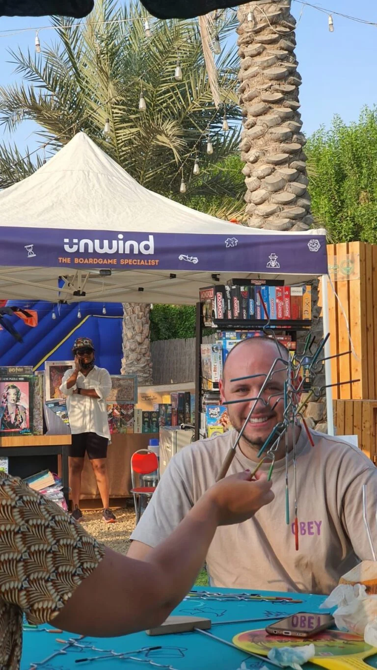 An Unwind Game Master playing with guests at an event stall