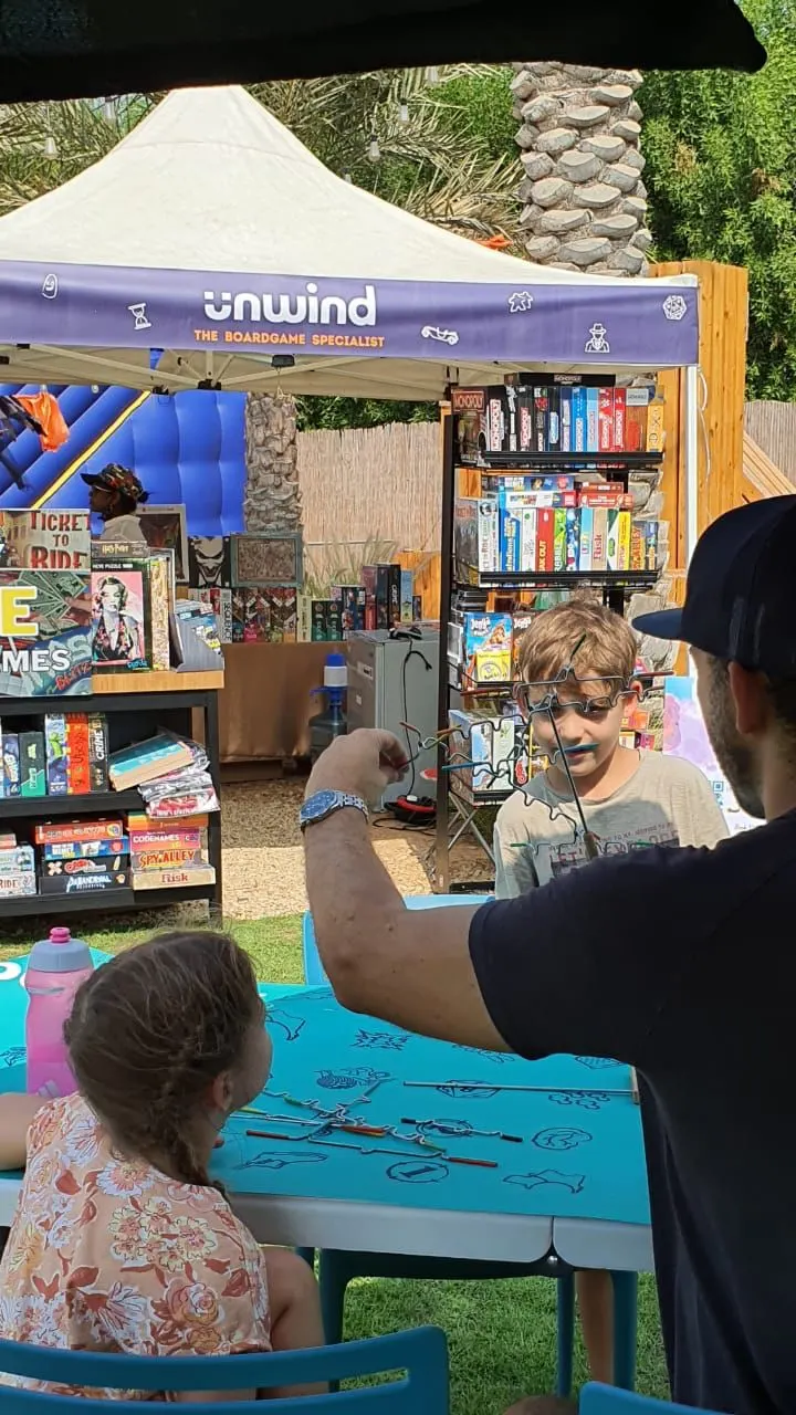 A Game Master teaching a child at an Unwind games stall